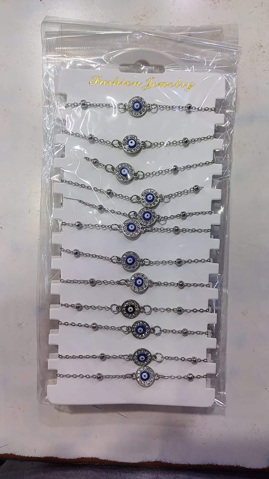🧿 Pulseras Plateadas con Ojo Turco x12 en Blister 🧿